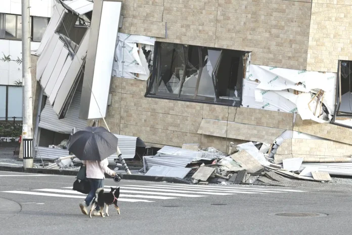 People walk a dog past a building collapsed by an earthquake in Yatsushiro, _result